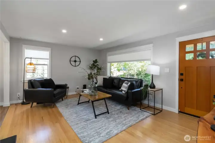 Bright living room featuring large windows, recessed lighting, and a welcoming layout for relaxing or entertaining.