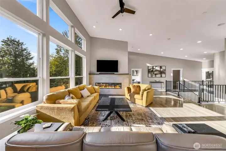 Open concept living room flooded with light and custom LED colored lit fire place