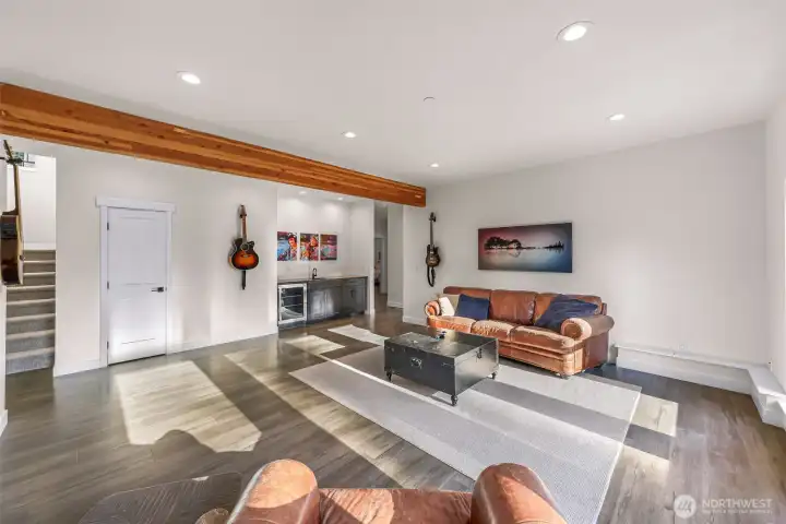 Light flooded down stairs rec room with wet bar and double doors out to fire pit and waterfalls