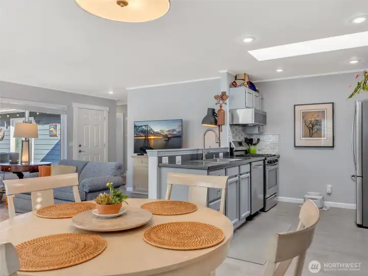 Living room, dining room, and kitchen. The main entry and hallway to the bedrooms are in the back.