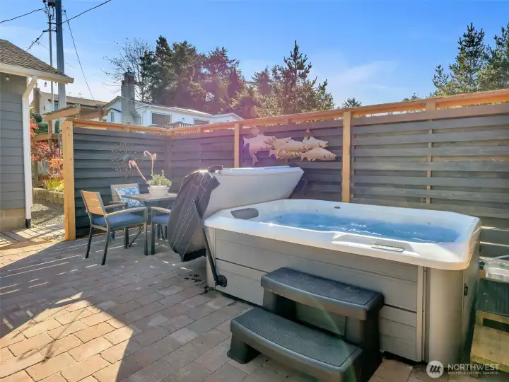 Secluded outdoor space with patio, deck, and hot tub.