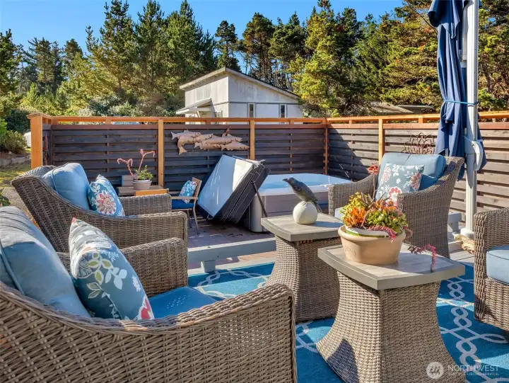 Secluded outdoor space with patio, deck, and hot tub.