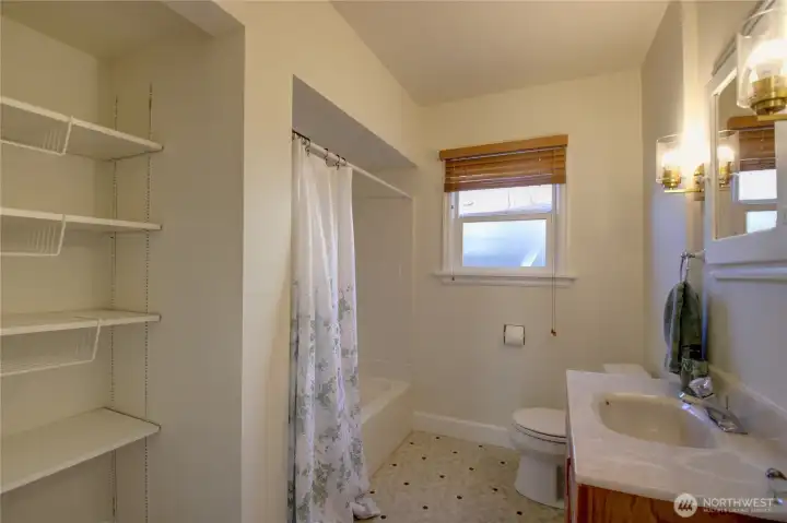 A full bathroom with plenty of storage.