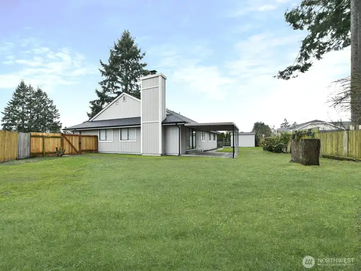 Side yard.  Fenced back yard. Over one quarter acre on cul-de-sac.  Gate on each side of home. Grass  has been staged more even green in areas.