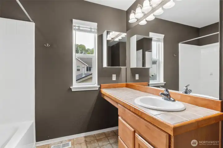 Primary bath with shower/tub combo, linen closet and toilet.