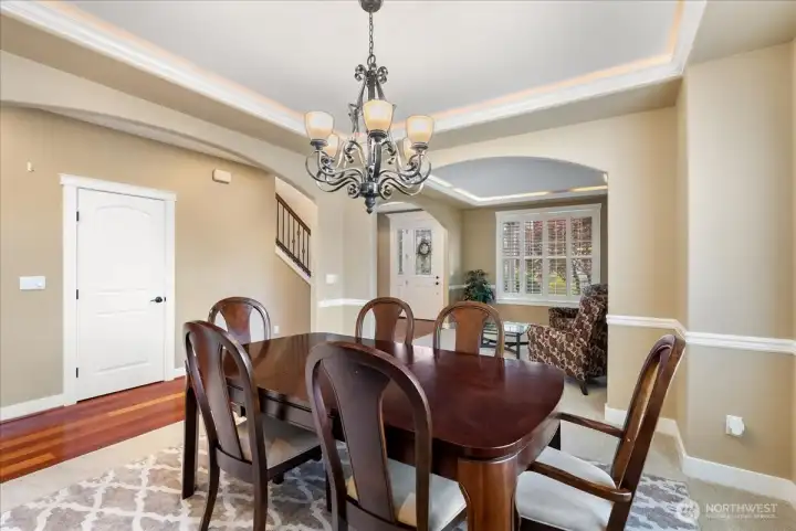 The dining room features stunning ambient lighting complemented by rich white millwork, creating an elegant open space.