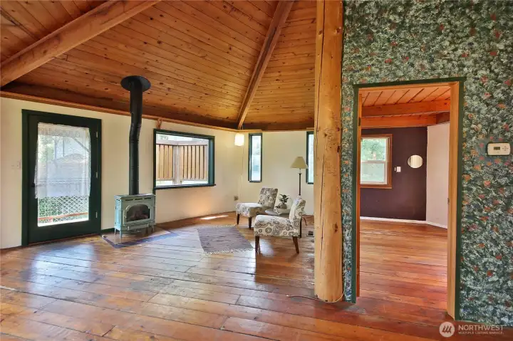 The main living area features hardwood floors and a cozy freestanding propane stove.