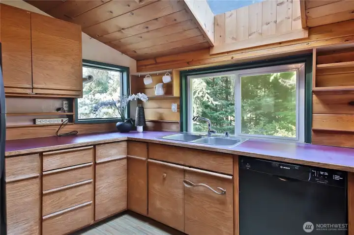 The kitchen is bathed in light from the skylight and surrounding windows.