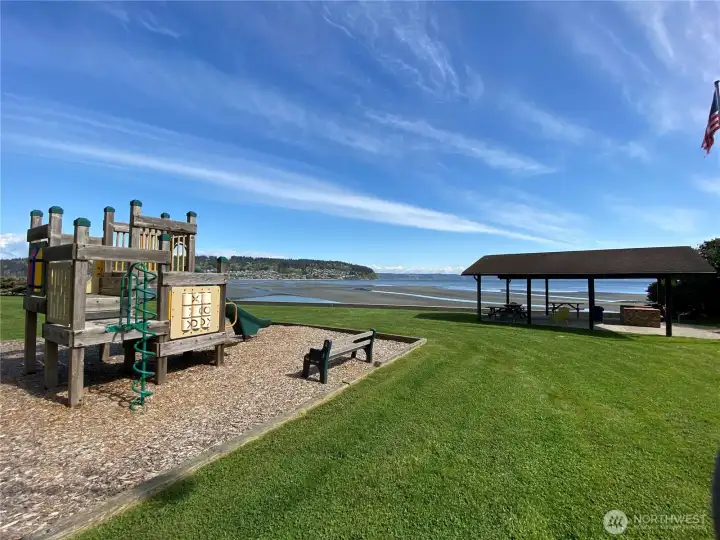 Beautifully landscaped playground and gazebo by the water.