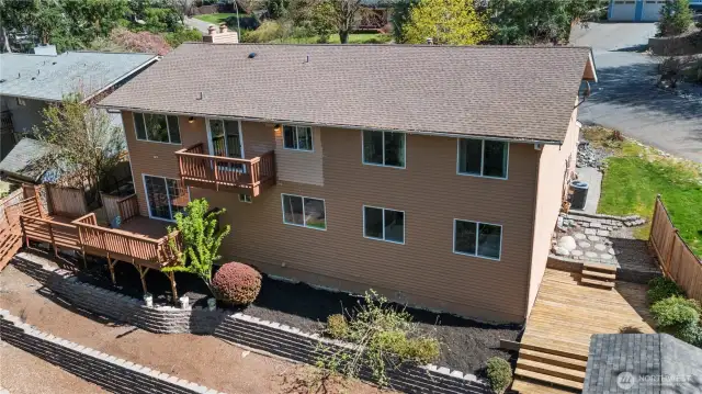 Backyard deck is perfect for entertaining, enveloped by a beautiful green space!