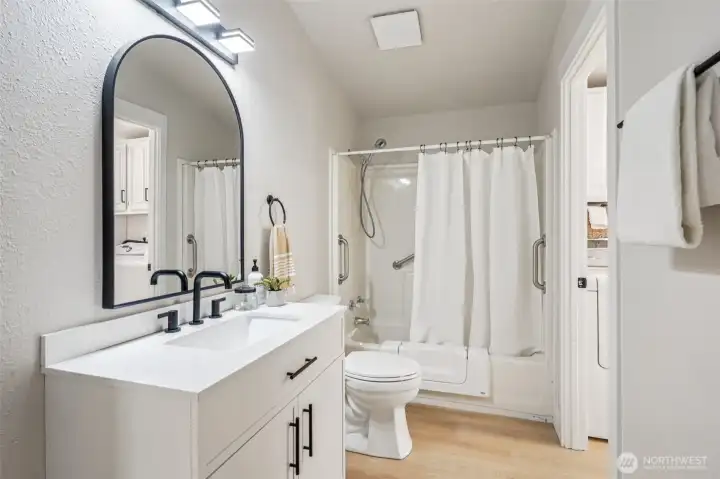 Guest bathroom with new vanity, with access to the hallway and to the laundry room.