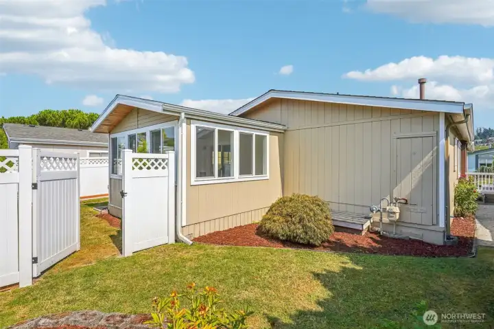 Backyard with convenient gate to provide a fully fenced area in case you have a pet.
