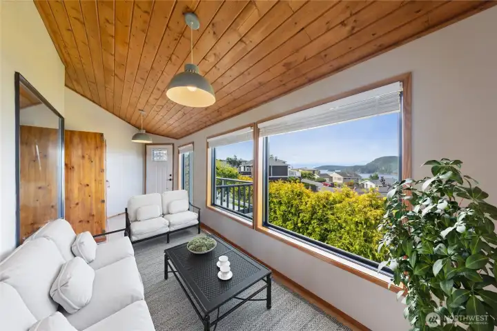 Enclosed sunroom with warm, wood ceilings to relax and enjoy the gorgeous views.