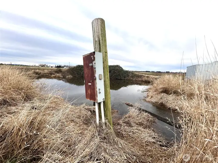 Storage pond fed by the creek. Electrical power box