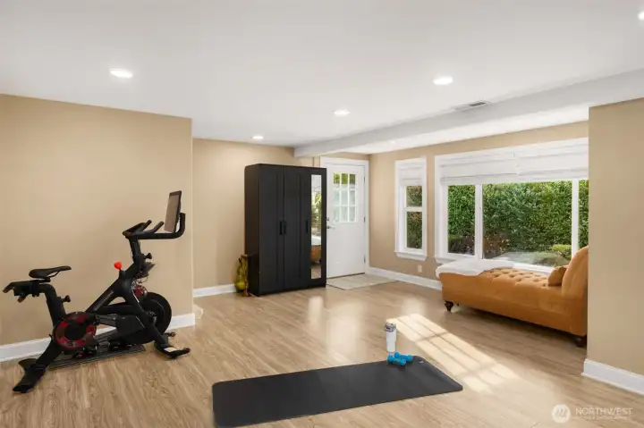 Lower level second flex space. Stairway leads up to the garage. The laundry room is to the right of the window/lounge.