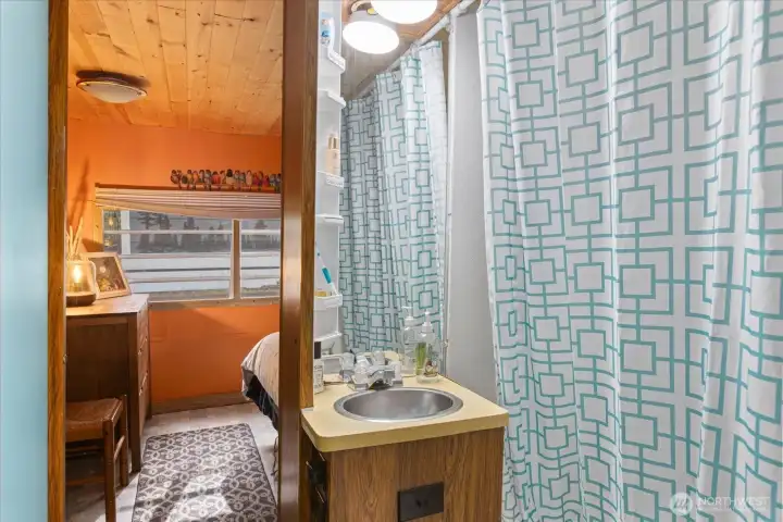 Bathroom just off the kitchen connects to the bedroom.