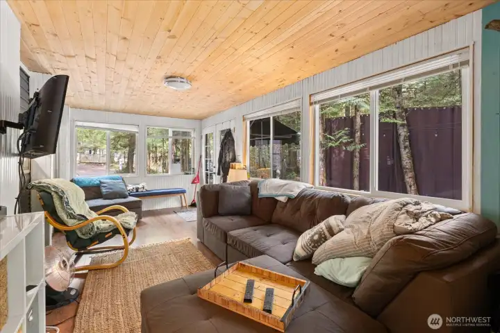 Privacy outdoor curtains have been hung along the tree line adding to the privacy inside and out.