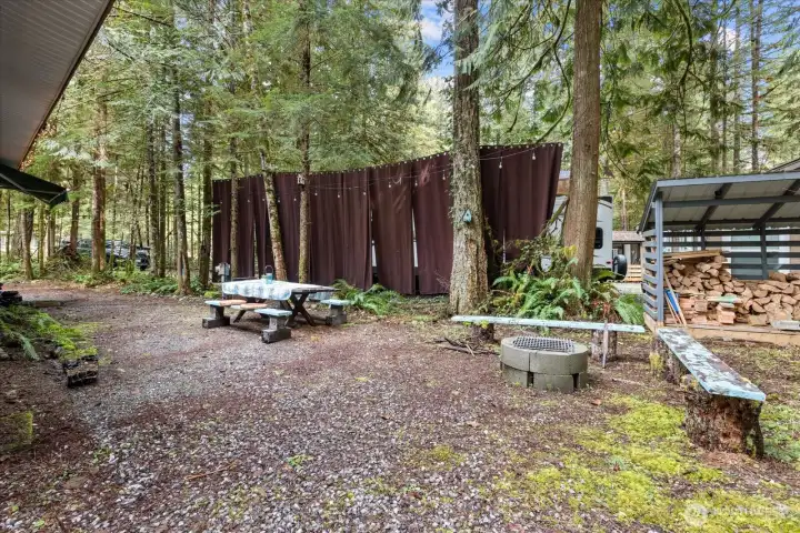 Picnic, firepit, privacy curtains, woodshed.