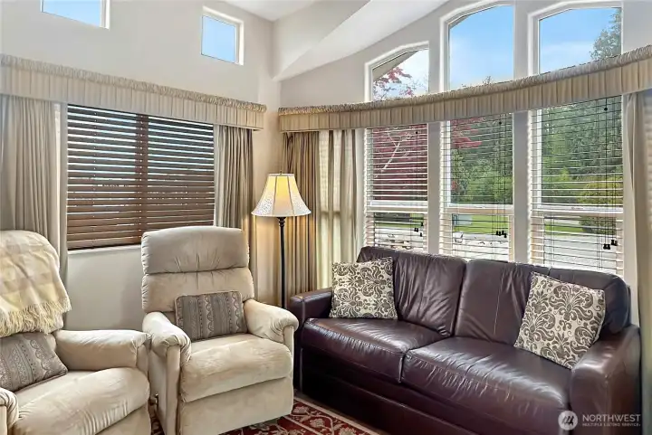 A welcoming, light-filled living space where vaulted ceilings and upper windows create a bright, airy retreat after a day at the beach.