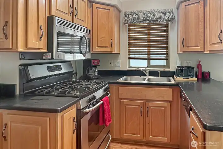 Beautiful wood cabinetry, stainless appliances and plenty of workspace on the solid surface countertops