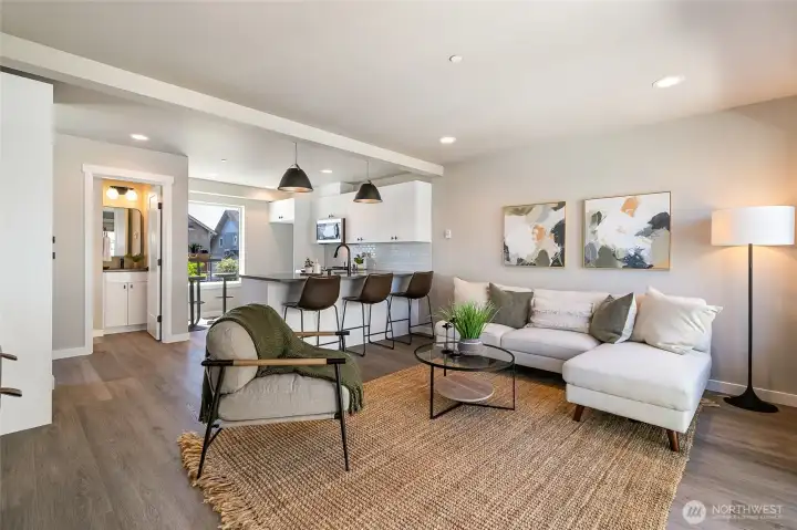 Warm & inviting living area with view of kitchen & powder room
