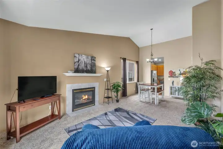 Spacious open-concept living and dining areas with vaulted ceilings create an airy feel that's perfect for both everyday living and entertaining. The gas fireplace serves as a warm focal point while the flowing layout offers excellent functionality.