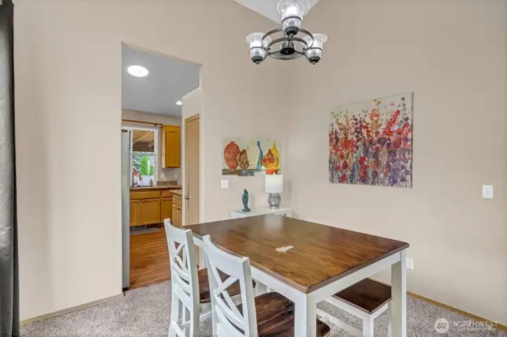 Light-filled dining room with soaring vaulted ceilings and an open design that flows seamlessly into the living room and kitchen—perfect for everyday meals or entertaining guests.