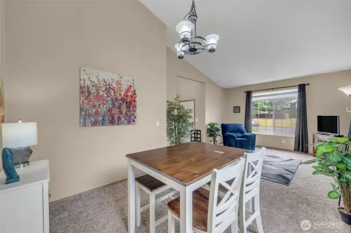 Spacious dining area with dramatic vaulted ceilings and an open floor plan that provides flexibility for both casual dining and holiday entertaining.