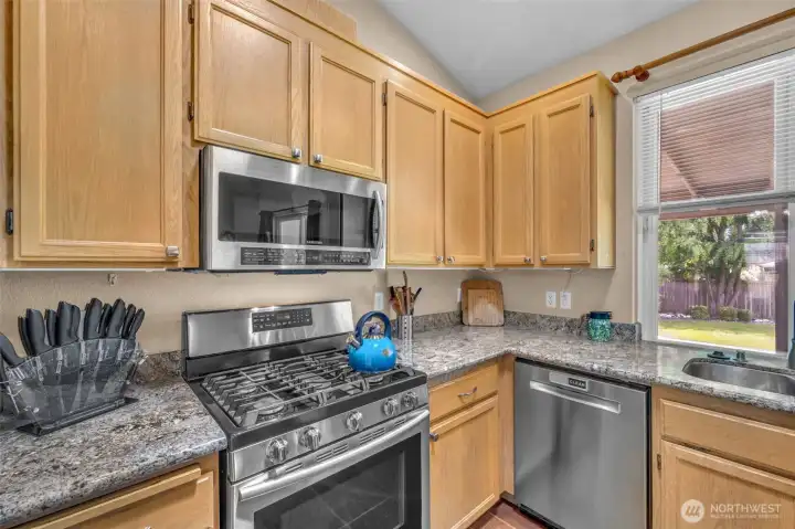 Well-appointed kitchen featuring warm maple cabinetry, granite countertops, stainless steel appliances, a gas range, and abundant cabinet and counter space for meal preparation.