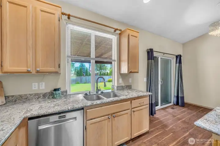 Enjoy preparing meals while overlooking the backyard from the double-basin sink. Sliding glass doors provide easy access to the covered patio, making indoor-outdoor entertaining effortless.