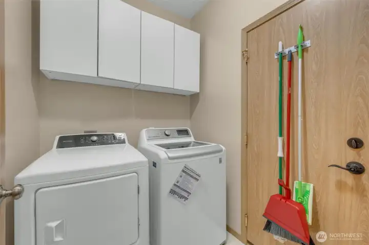 Convenient laundry room with upper storage cabinets and direct access to the garage, making everyday chores simple and efficient.