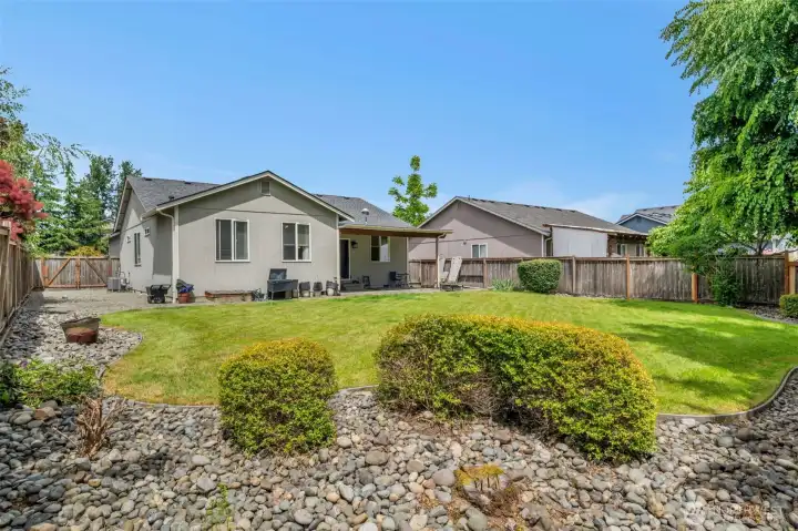 Enjoy the fully fenced backyard featuring a spacious level lawn, attractive landscaping, and a covered patio—perfect for outdoor entertaining, pets, gardening, or simply relaxing.