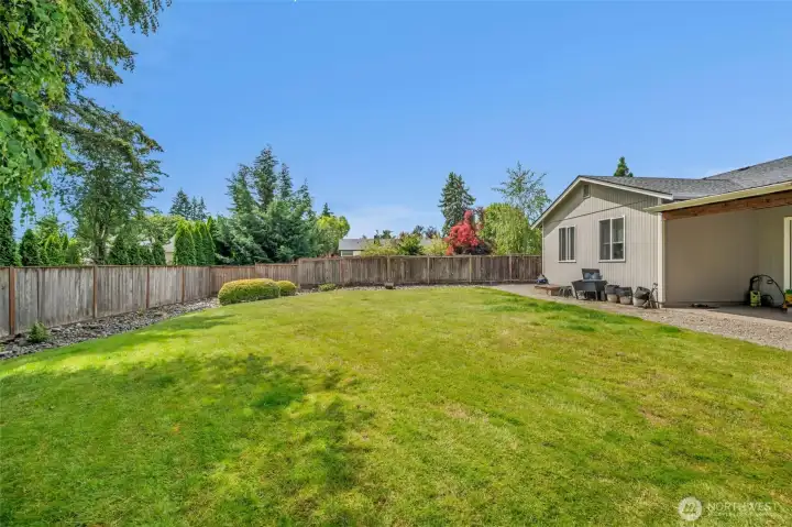 Private backyard retreat featuring an expansive lawn, attractive landscaping, and a peaceful setting that's ideal for enjoying the outdoors.