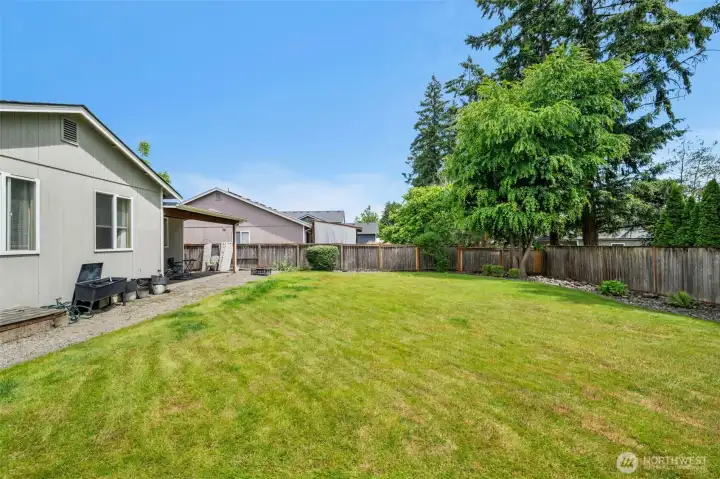 Enjoy a generous backyard with ample room for outdoor activities, gatherings, or future garden beds, all surrounded by mature landscaping for added privacy.
