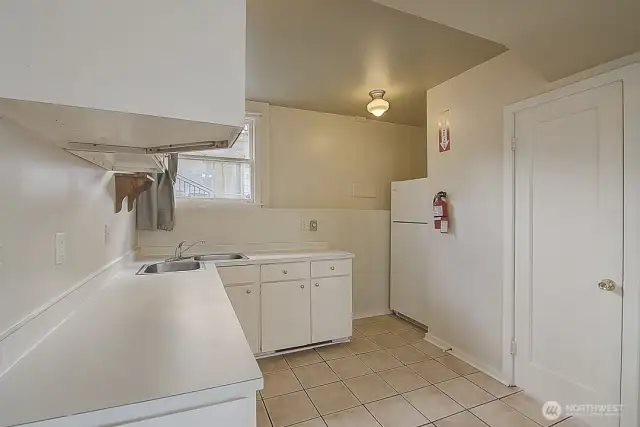 Lower unit kitchenette, view 1, showcasing cabinets, sink, and refrigerator.