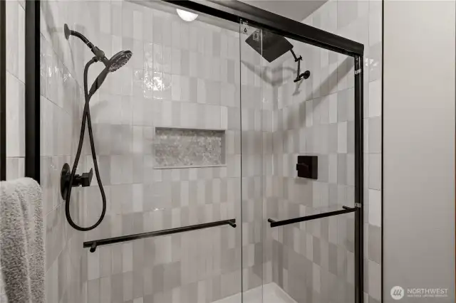 Beautiful shower tiling features a built-in tiled shelf, keeping the shower floor clutter-free and enhancing both style and functionality.
