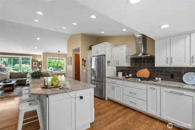 The main level feels open and airy, featuring vaulted ceilings, a skylight, and an open floor plan that enhances the sense of space and natural light.