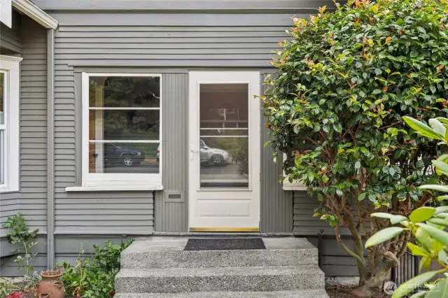 Completely enclosed front porch is so welcoming!