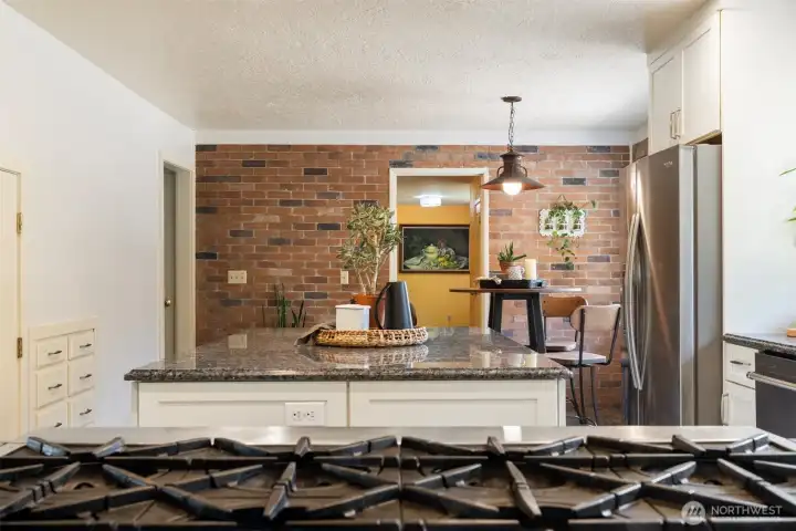 The chef’s kitchen is a showstopper, featuring granite counters, a premium gas range, and an oversized walk-in pantry—perfect for entertaining or farm-to-table cooking using your own fresh-picked produce from established fruit trees, berries, grapevines, and raised garden beds.