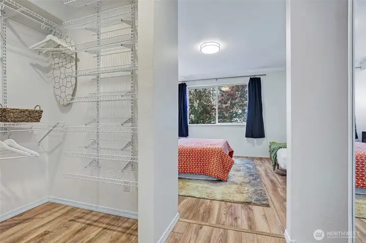 Large walk-in closet in the bedroom with built-in shelving.