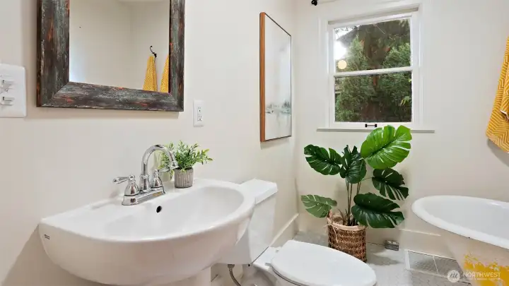 The second main-level bathroom impresses with gorgeous tilework, a sleek low-profile sink, and a deep soaking tub that invites you to unwind in style.