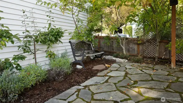 Flagstone pavers guide you beneath the grape arbor, creating a storybook path that leads to the side gate. It’s a charming touch that makes this side yard feel truly special.