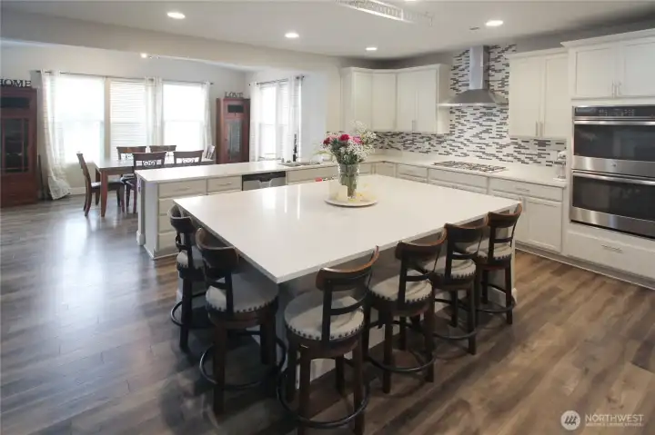 The STUNNING kitchen is loaded with upgrades, including an beautifully oversized quartz island.