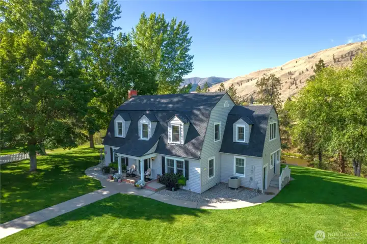 "A timeless river estate where classic farmhouse charm, expansive lawns, and the beauty of the Methow Valley create an unforgettable setting."