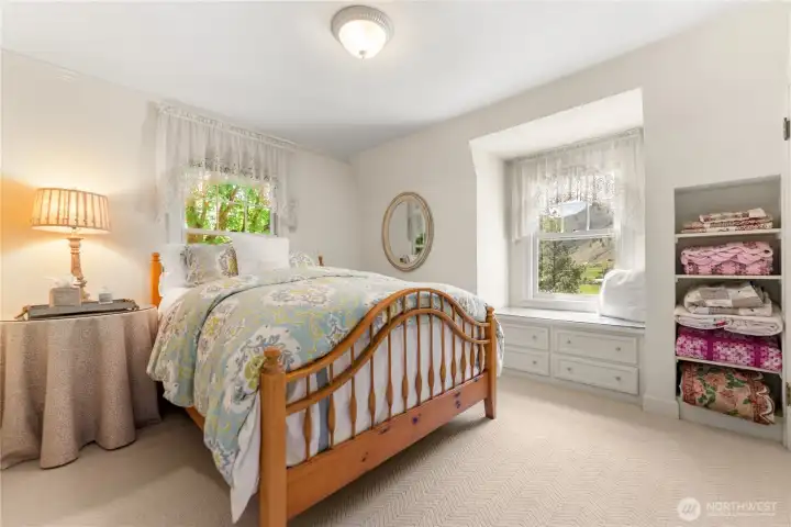 Upstairs guest room; peaceful and light-filled, this guest room offers a cozy retreat with vintage shelving and pastoral vistas of the rolling hills and river beyond.