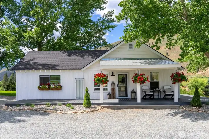 Charming 2-bedroom guest house with covered porch, flowering window boxes, and private deck—ideal for hosting friends, extended stays, or enjoying your own tranquil retreat.
