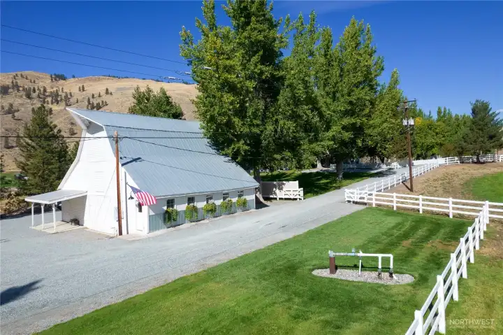 Charming historic barn with metal roof and flower boxes—perfect for storage, animals, or hobby use, all framed by sweeping mountain views and timeless rural character.