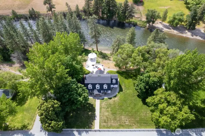 "Tucked among towering trees along the Methow River, this classic farmhouse estate offers a timeless blend of privacy, beauty, and connection to the outdoors."