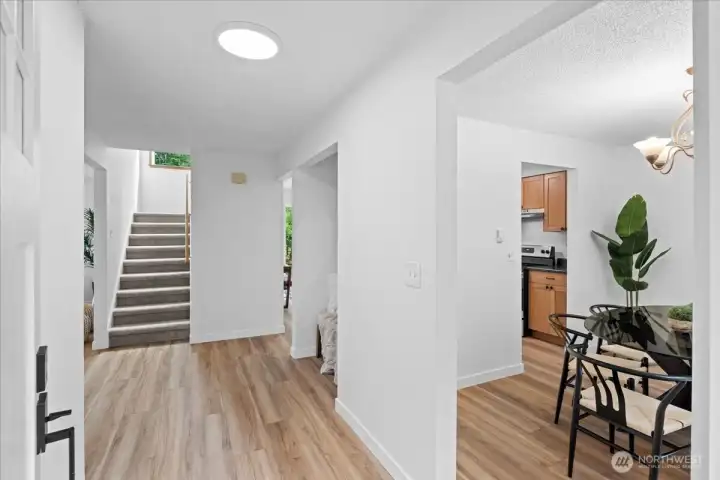 Entryway – Bright entry foyer with new LVP flooring, clean finishes, and staircase access to the upper level. Open sightlines connect the main living areas.