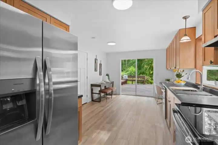 Kitchen – Functional kitchen with stainless steel appliances, ample cabinetry, and dining nook space. Sliding glass doors provide direct access to the outdoor deck.